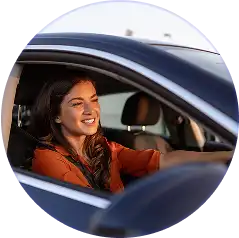 A picture of woman smiling besides a car